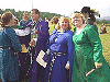 Mistress Rhiannon and Baroness Eliska smile for the camera as Master Peter and Lady Anne-Marie confer. Click here for full size image.