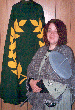 Siobhn stands before her Laurel cloak made for her by Bran and holding the giant drop spindle Oshi made for her as a vigil gifts. Click here for full size image.